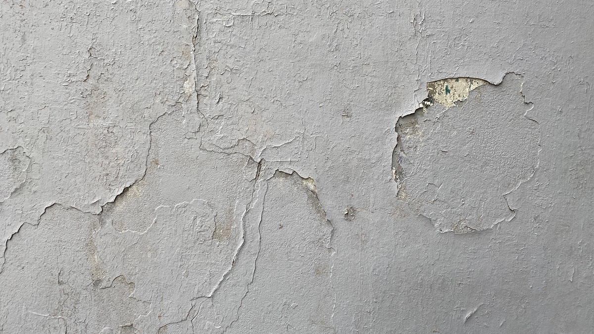 white paint peeling off a wall
